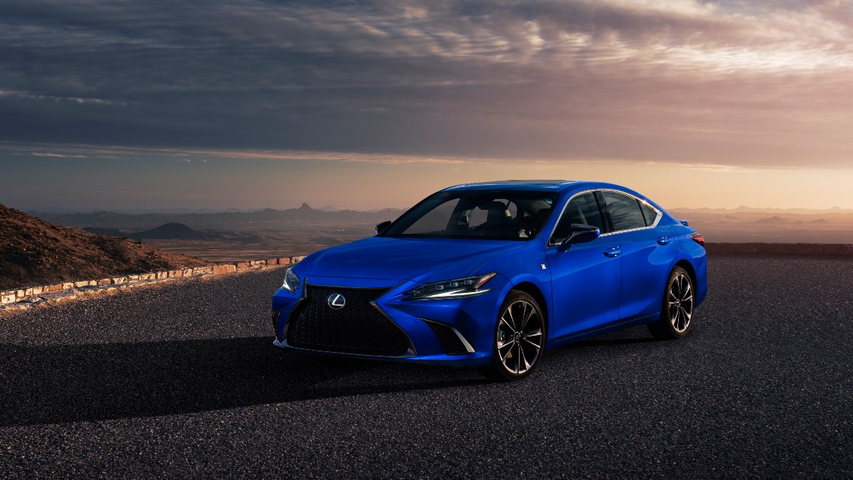 a blue 2022 Lexus parked with the sunset behind it