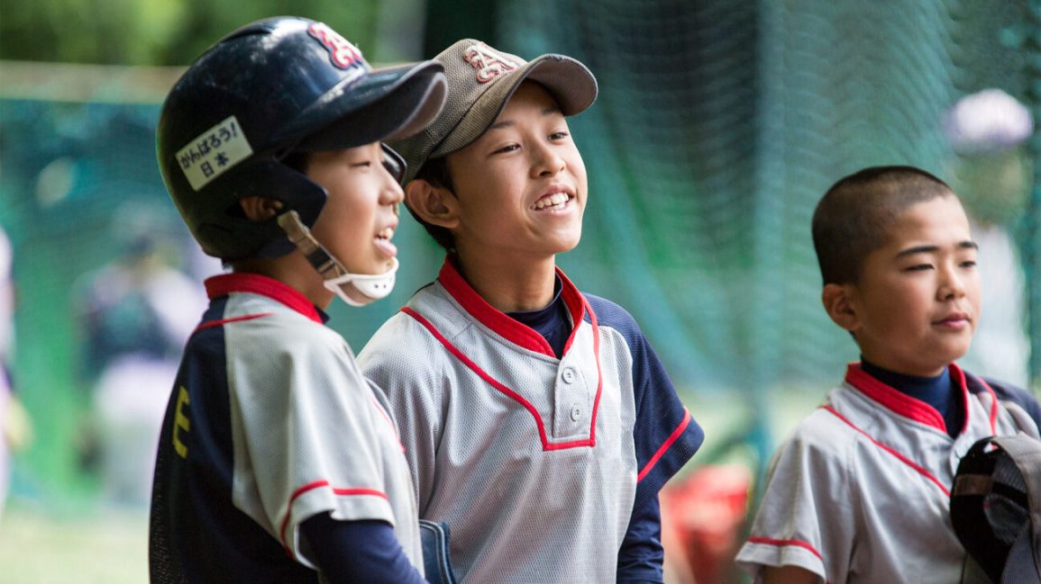 Three baseball players are enjoying a moment in the dugout